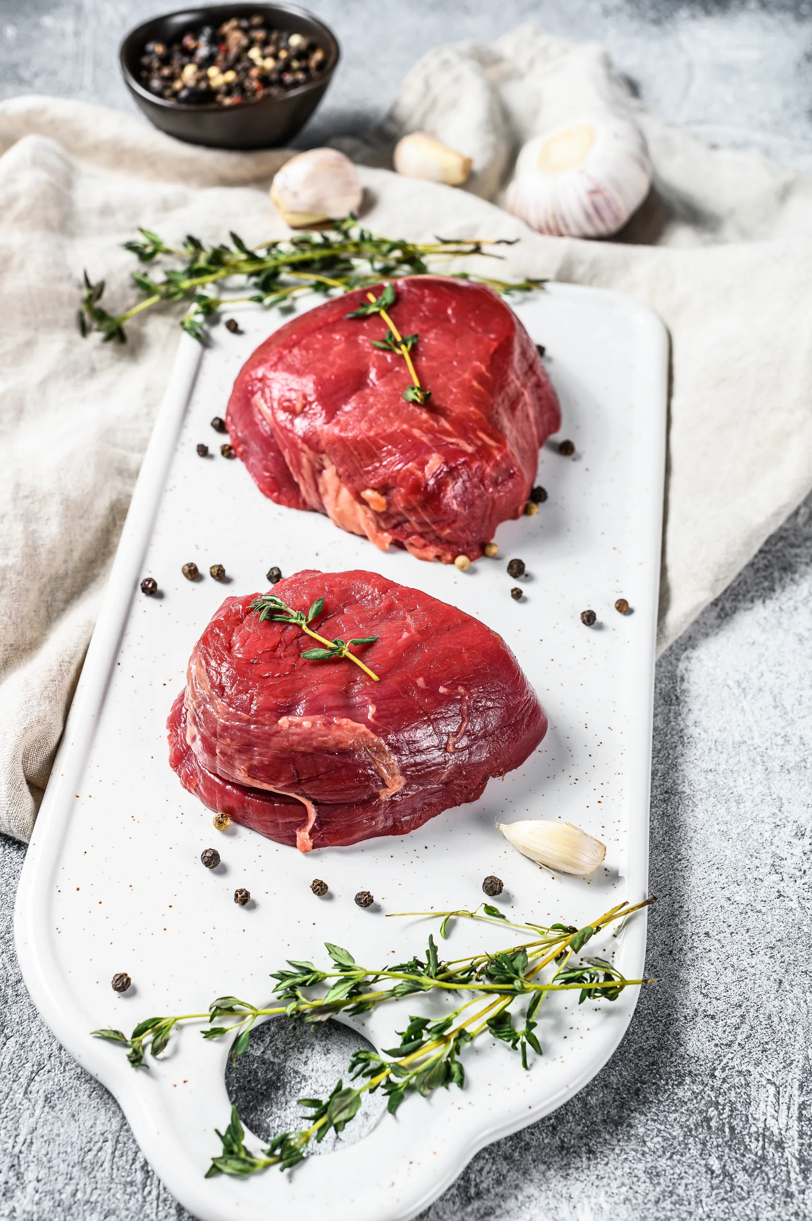 Fresh raw beef steaks arranged on a board