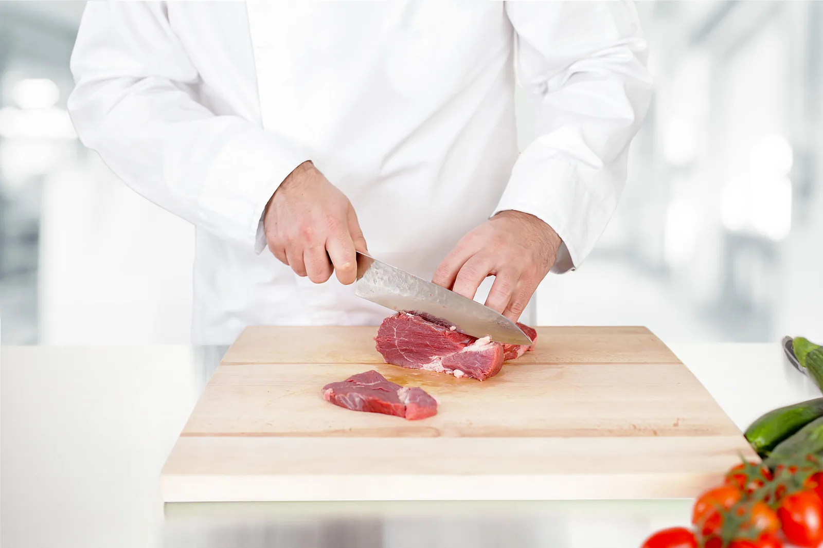 Food technician working with fresh meat in a professional processing environment